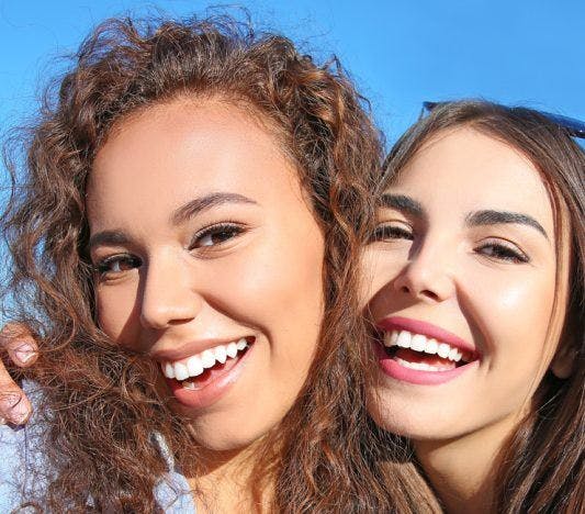 Two women smiling and taking a selfie together.
