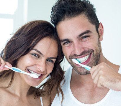 Couple brushing teeth in the bathroom.