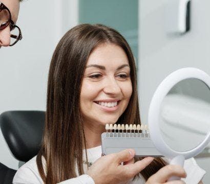 Woman getting her teeth checked for dental veneers.