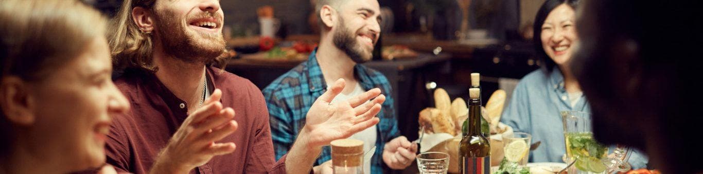 Group of friends laughing over dinner.