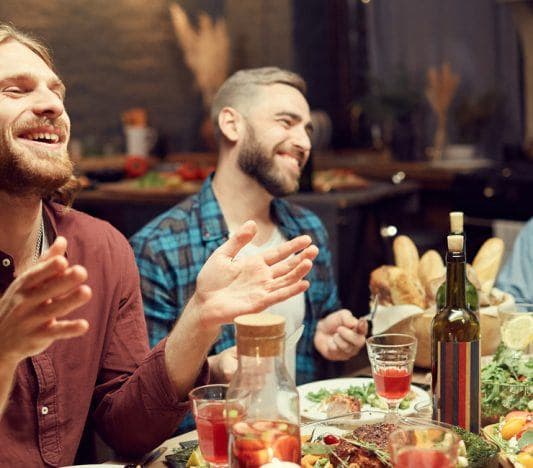 Group of friends laughing over dinner.