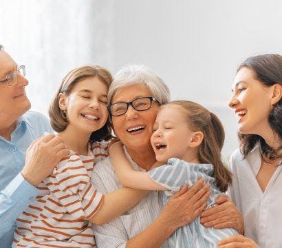A multigenerational family smiling and hugging.