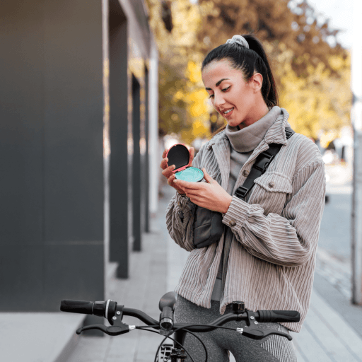 Woman biking outdoors, holding her ClearCorrect aligners.