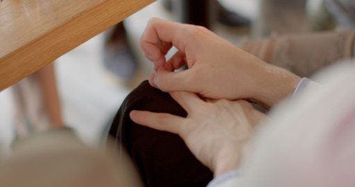 Cropped photo of woman picking on her nails.